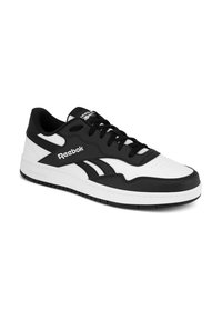 Czarno-białe niskie trampki Reebok z czarnymi sznurówkami, logo po boku i na języku oraz białą podeszwą z czarnym bieżnikiem.