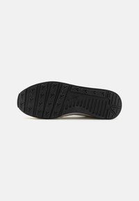 Black rubber shoe sole featuring patterned treads and ridges, with a smooth edge and slight curve at the toe section.