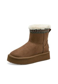 Stivale alla caviglia in suede marrone con una fodera in pelliccia bianca, cuciture decorative attorno al polsino e una suola spessa.