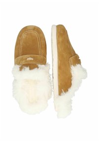 Bruna mockasiner i mocka med vit faux fur-foder, rund tås, och vit gummisula. Har sömdetaljer och en liten dekorativ accent.