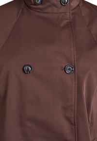 Brauner doppelseitiger Mantel aus glattem Stoff, mit hohem Kragen, zwei schwarzen Knöpfen und sichtbaren Nahtdetails.