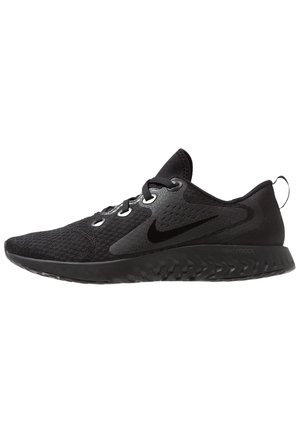 Black athletic shoes feature a breathable mesh upper, rubber outsole, and prominent Nike swoosh logo. Laces and pull tab accent the design.