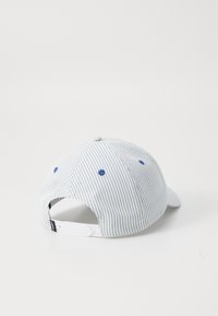Stribet blå og hvid baseballcap med en buet skygge, stofbetrukket knap på toppen og justerbar hvid plastikrem bagpå.