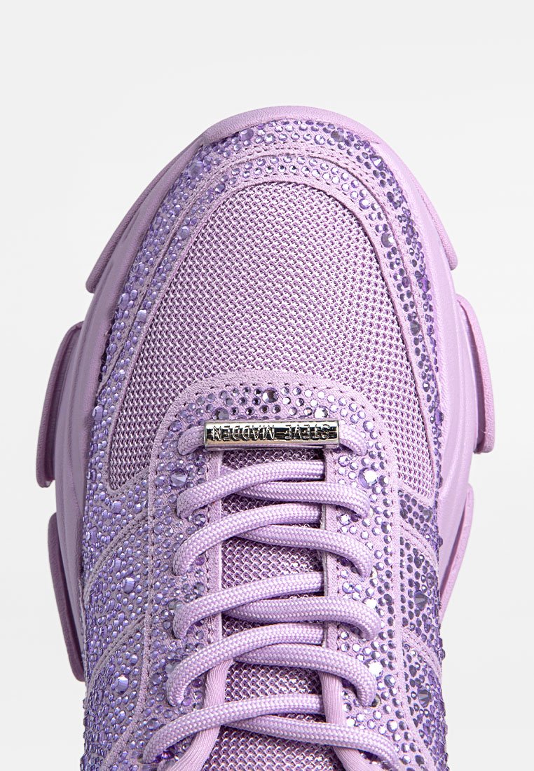 Lila Turnschuhe aus Mesh-Material mit glitzernden Verzierungen, flachen Schnürsenkeln und einer dicken, runden Sohle. Metallisches Branding auf der Zunge.