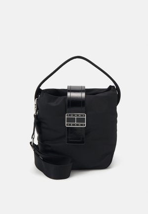 Sort Tommy Jeans skuldertaske med topgreb, justerbar rem og frontrem med logoplade.