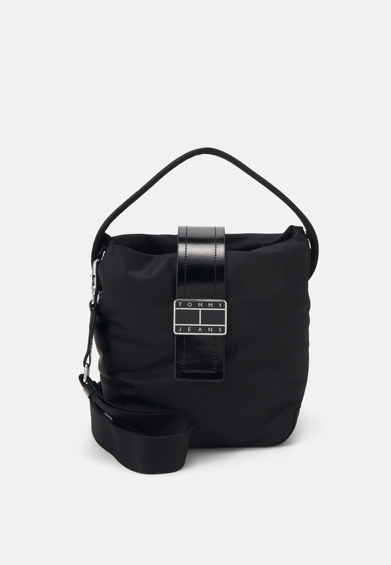 Sac d'épaule noir Tommy Jeans avec poignée supérieure, bandoulière réglable et sangle avant avec plaque logo.