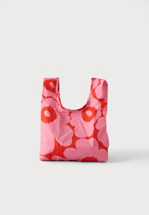 Sac de courses réutilisable avec motif floral rose et rouge, posé debout sur un fond uni clair.
