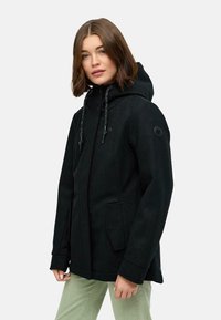 Veste à capuche noire en tissu texturé semblable à de la laine, avec fermeture éclair à l'avant, cordons de serrage et poches latérales pour plus de fonctionnalité.