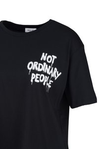 Zwarte T-shirt met korte mouwen met witte, druipende tekst op de borst die "NIET ORDINAIRE MENSEN" in hoofdletters leest.
