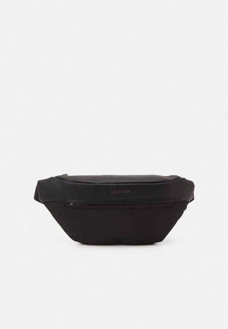 Marsupio in nylon nero con una superficie liscia, forma curva, chiusura con zip superiore e dettagli del logo goffrati discreti. Presenta una tasca esterna con zip.
