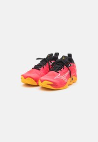 Scarpe da corsa rosse e gialle con parte superiore in rete, lacci neri e accenti con logo. Suola arrotondata con un motivo testurizzato per la trazione.