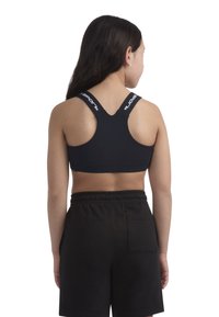 Melnā sporta krūšturis ar plašām siksnām, kas rotāts ar baltajiem logo detaļām. Dizains ietver sacīkšu aizmuguri un pieguļošu siluetu. Valkāts kopā ar melnām biksēm.