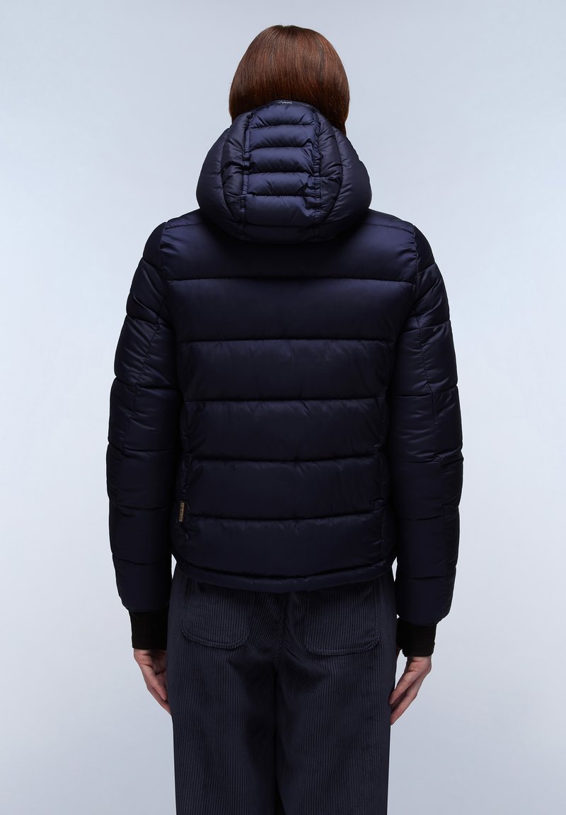 Veste doudoune marine avec un design matelassé, capuche attachée et poignets côtelés. Présente une texture lisse et un détail de logo sur le côté gauche.