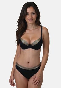 Musta bikinit-setti, jossa on rakenteellinen rintaliivi kultaisella verkkoyksityiskohdalla ja yhteensopivat alushousut, joissa on kultaisin korostuksin varustettu vyötärö. Silkkinen pinta.