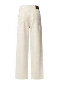 Pantalones de mezclilla de pierna ancha, de color claro, con una cintura alta, que presentan dos bolsillos traseros y un sutil patrón de rayas verticales. Parche de marca de cuero marrón.