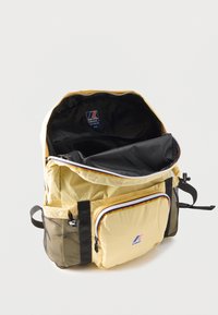 Κίτρινο σακίδιο πλάτης K-Way με μπροστινή τσέπη με φερμουάρ, διχτυωτές πλαϊνές τσέπες, μαύρο εσωτερικό και μερικώς ανοιχτό κύριο διαμέρισμα.