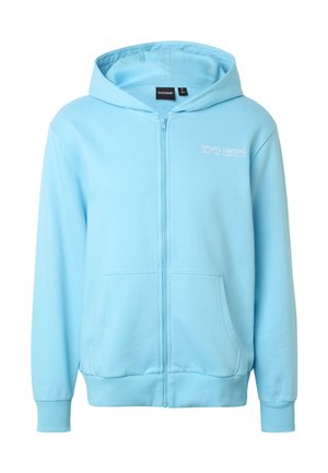 Sweat à capuche zippé bleu clair avec poches avant, poignets côtelés, et texte "bruno banani" sur le côté gauche de la poitrine sous la capuche.