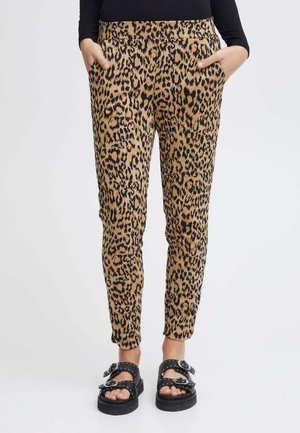 Pantalons à imprimé léopard dans une combinaison de couleurs beige et noir, avec des poches latérales et une coupe ajustée, fabriqués en tissu doux et extensible.