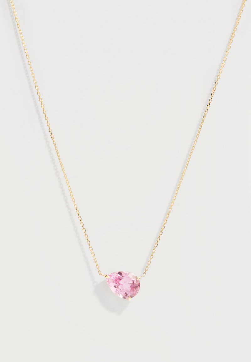 Λεπτή χρυσή αλυσίδα με μοναδικό μενταγιόν σε σχήμα αχλαδιού, ροζ πολύτιμη πέτρα, στο κέντρο πάνω σε ανοιχτό φόντο.