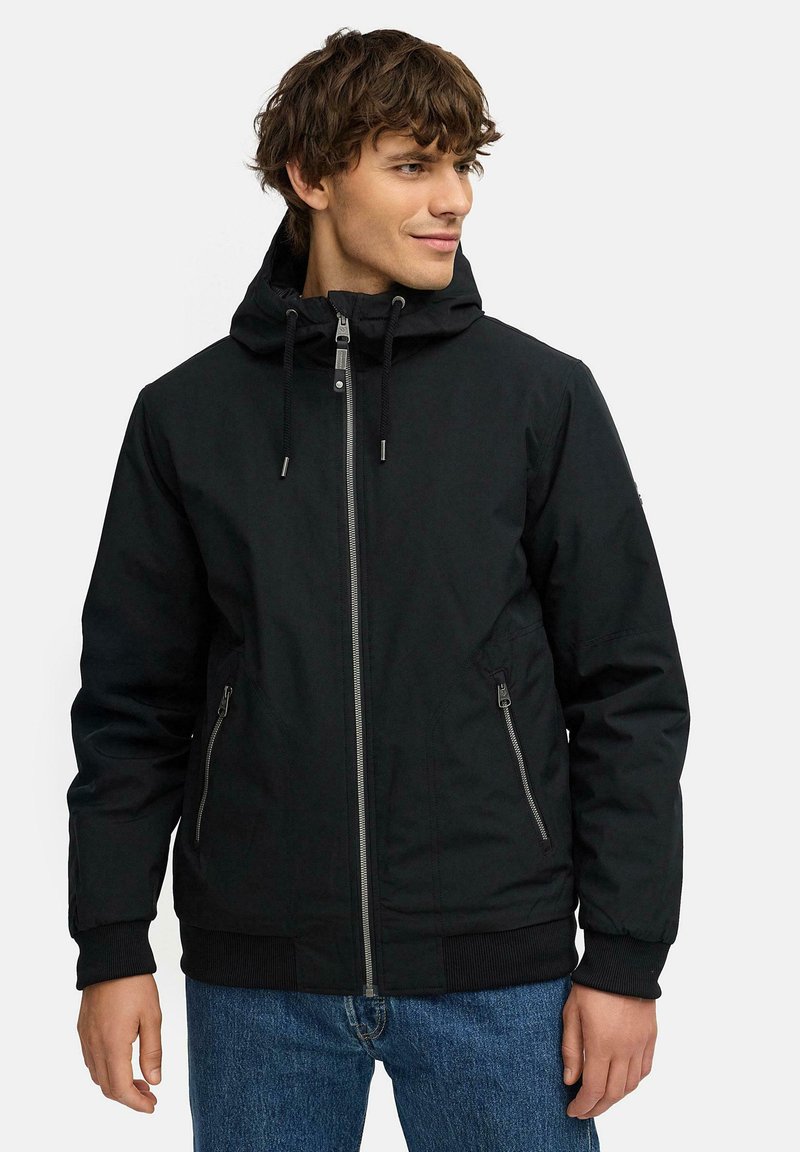 Svart vattentät jacka med dragkedja fram, justerbar huva, två sidfickor och ribbade ärmslut samt nederkant. Slät tygstruktur med minimalistisk design.