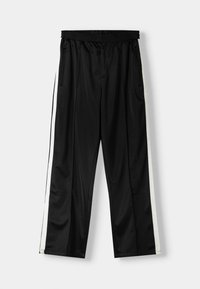 Černé sportovní kalhoty volného střihu s elastickým pasem, bočními kapsami a bílými pruhy podél vnějších švů. Hladký povrch.