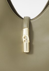 Borsa verde oliva con una texture in pelle liscia, caratterizzata da una chiusura in metallo color oro e un design a forma curva nella parte superiore.