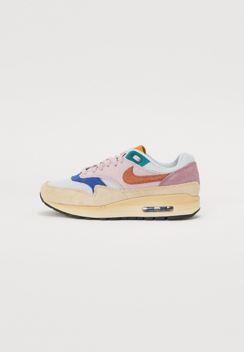 Multicolor sneaker met een basis van wit, roze en oranje accenten, een blauwe logo en zichtbare luchtkussens, gemaakt van mesh en suède materialen.