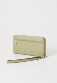Portefeuille en cuir vert clair avec une finition texturée, fermeture éclair, poche arrière et une sangle de poignet détachable. Détails en métal doré.