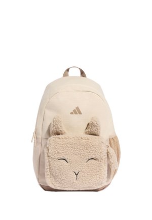 Beigen värinen reppu, jossa edessä pörröinen tasku hymyilevän eläimen kasvon muotoisena korvilla, sivulla verkkotasku ja Adidas-logo yläosassa edessä.