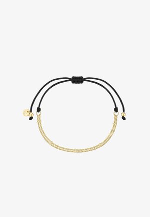 Bracelet en cordon noir ajustable avec deux chaînes parallèles dorées et de petites perles dorées, avec un pendentif doré à une extrémité.