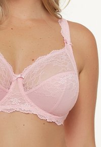 Roze kant BH met gaaspanelen, versierd met bloemmotieven, verstelbare bandjes en een klein strikje in het midden voor.
