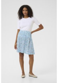 Light blue floral skirt with gathered waist, featuring small white and green flower patterns; paired with a white fitted short-sleeve top.