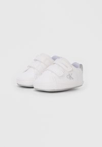 Beli platneni čevlji z dvema ježkoma, okrogel nos in sivimi poudarki. Na strani srebrni Calvina Kleina logotip. Ravna podplat.