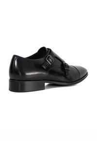 Black leather shoe with a sleek design, featuring a rounded toe, small heel, and two adjustable buckles on the side. Smooth texture.