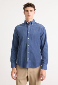 Blauwe button-down overhemd gemaakt van gestructureerde stof, met een klassieke kraag en lange mouwen. Opvallend geborduurd logo op de borst.