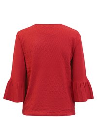 Röd topp med ett strukturerat mönster på kroppen och utställda plisserade ärmar. Mjukt tyg, rund halsringning och enkel ryggdesign.