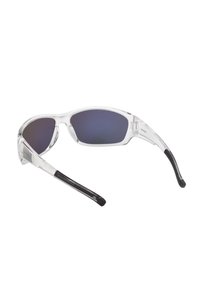 Lunettes de soleil avec monture transparente, verres teintés foncés et branches en caoutchouc noir, présentées sur un fond blanc.