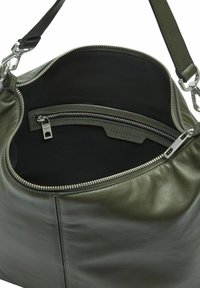 Sac à épaules en cuir vert foncé avec une fermeture éclair argentée et un intérieur en tissu noir, comportant une poche zippée intérieure.