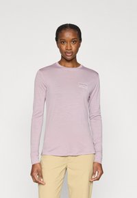 Μπλούζα μακρυμάνικη σε λιλά χρώμα, κατασκευασμένη από μαλακό υλικό. Διαθέτει μικρό λογότυπο Patagonia στο στήθος. Στρογγυλή λαιμόκοψη και εφαρμοστή σχεδίαση.