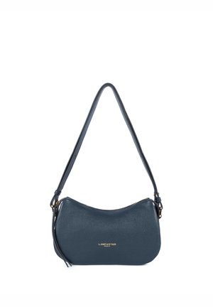 Dark blue leather handbag with a smooth texture, curved shape, a long strap, and gold logo detailing on the front. Zipper closure at the top.