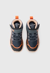 Des chaussures de sport bleu et orange avec une tige texturée, des lacets élastiques, une sangle en velcro et une semelle beige avec un léger profil.
