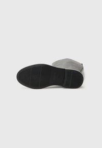 Mustad musteplaat, mille sileda ülaservaga ja tekstuurse kummitaldaga. Omab kerget kanna ja ei sisalda kaunistusi. Puhtad jooned ja minimalistlik profiil.