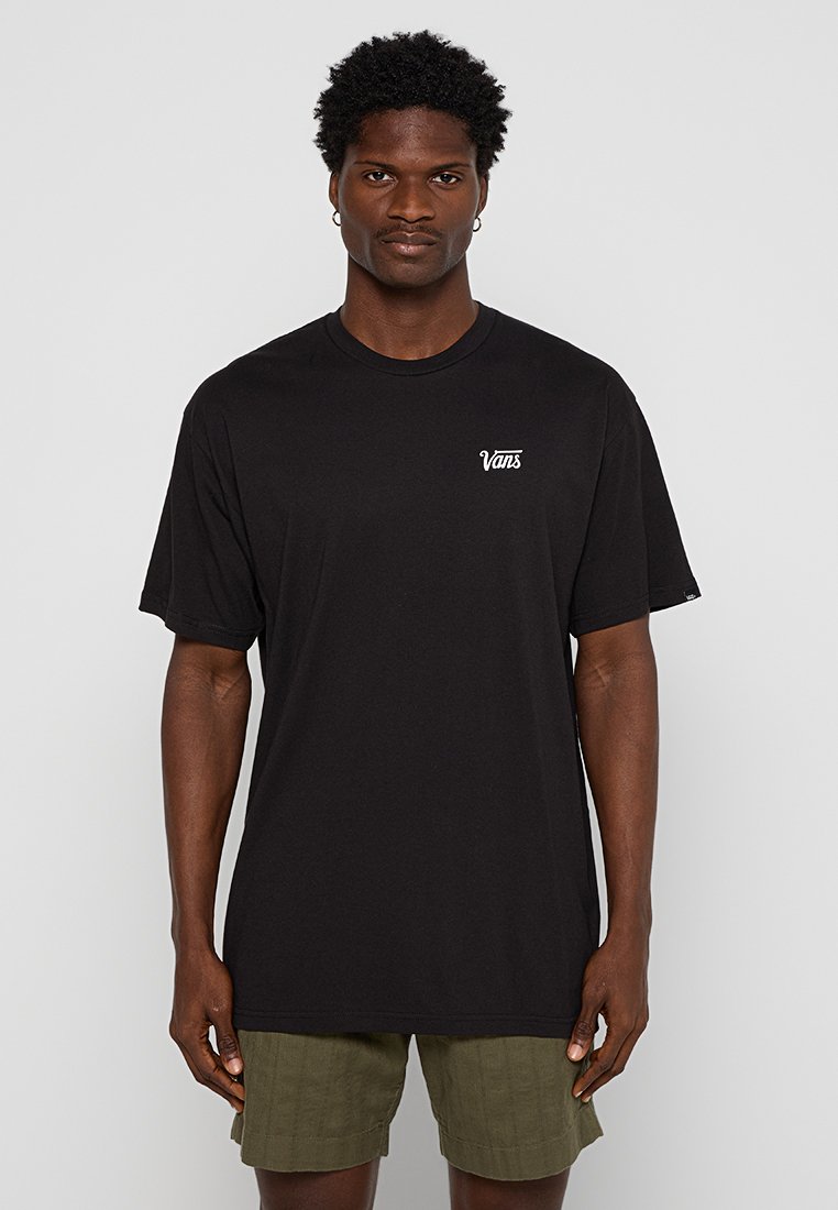 Camiseta negra de manga corta hecha de algodón, con un pequeño logotipo blanco de Vans en el pecho. El diseño es holgado y simple.