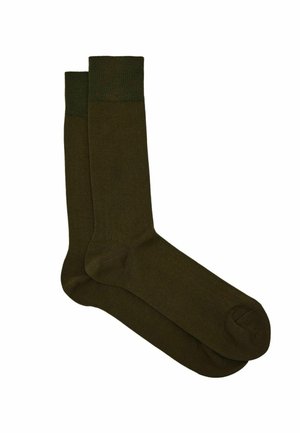 Para ciemnooliwkowych skarpetek do kostki z prążkowanym ściągaczem, gładką fakturą i zaokrąglonym czubkiem, ułożonych na płasko na białym tle.