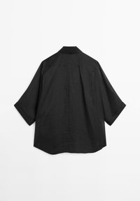 Schwarzes Leinenhemd mit entspannter Silhouette, Stehkragen und weiten kurzen Ärmeln, sauberen Rückendesign und ohne sichtbare Verschlüsse.