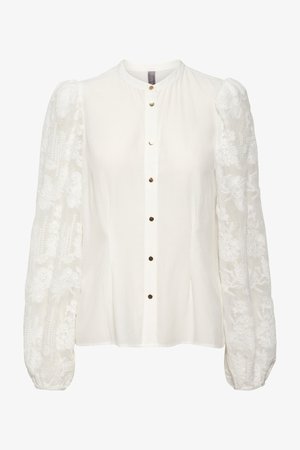 Balta blūze ar garām, pūkainām mežģīņu piedurknēm, apaļu kakla izgriezumu un priekšpusi ar pogu aizdari, kas rotāta ar mazām metāla pogām.