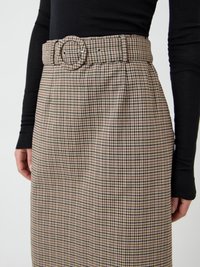 Praktiline seelik pruunide ja beežide ruuduliste mustritega, laia vööga, millel on ümmargune pandlaga ning volditud detailidega. Materjal näib olevat struktuurse ja tekstuuriga.