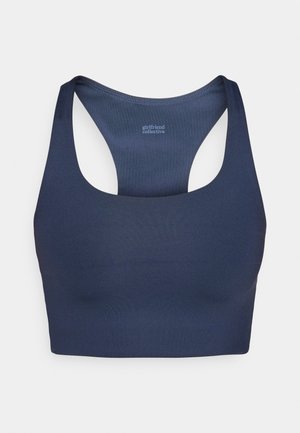 Navy blue sports bra made from smooth, stretchy fabric, featuring a racerback design and subtle logo on the inside.