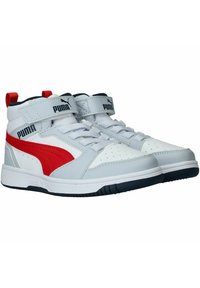 Weiße High-Top-Sneaker mit roten und grauen Akzenten, ausgestattet mit einer perforierten Zehenkappe, Schnürung und Klettverschluss sowie einer dunklen Gummisohle.