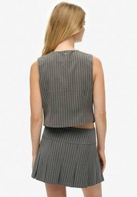 Szary paskowany zestaw składający się z crop topu i spódnicy o dopasowanym kroju, z bezrękawowym fasonem, rozkloszowaną spódnicą i miękką teksturą.